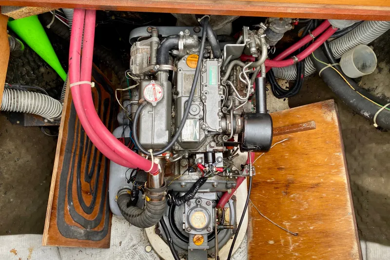 Slide: The Image of Engine compartment of a 2005 Lagoon 380 S2 catamaran with visible hoses and components. - 104