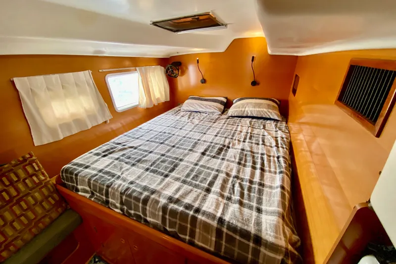 Slide: The Image of Cozy cabin interior of 2005 Lagoon 380 S2 catamaran with double bed and window. - 71