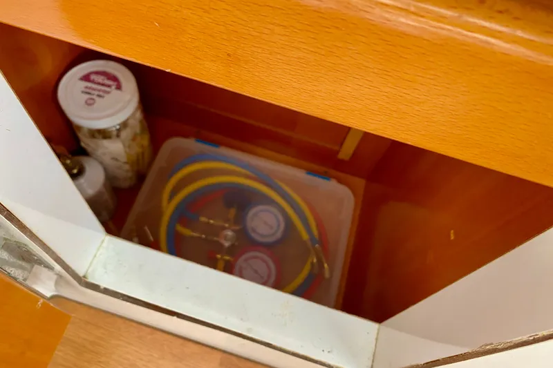 Slide: The Image of Storage compartment in a 2005 Lagoon 380 S2 with tools and jars. - 131