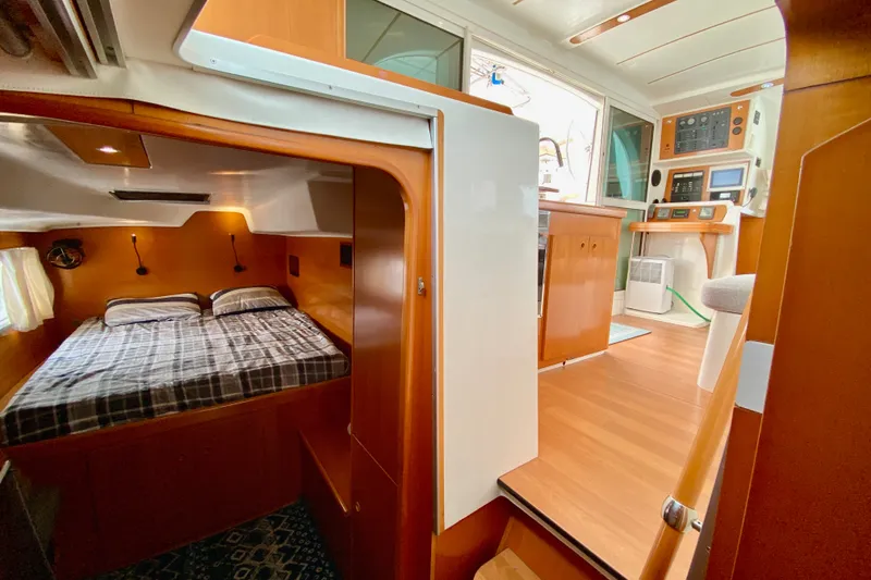 Slide: The Image of Interior of 2005 Lagoon 380 S2 catamaran featuring cozy cabin and navigation area. - 80