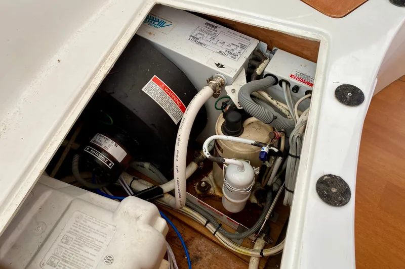 Slide: The Image of Engine compartment of a 2005 Lagoon 380 S2 catamaran, showcasing mechanical components and wiring. - 139