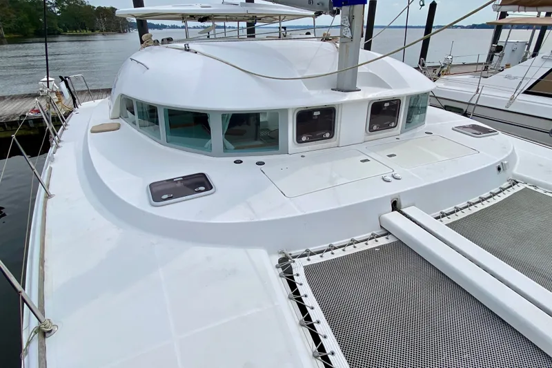 Slide: The Image of 2005 Lagoon 380 S2 catamaran docked, showcasing deck and cabin windows. - 18