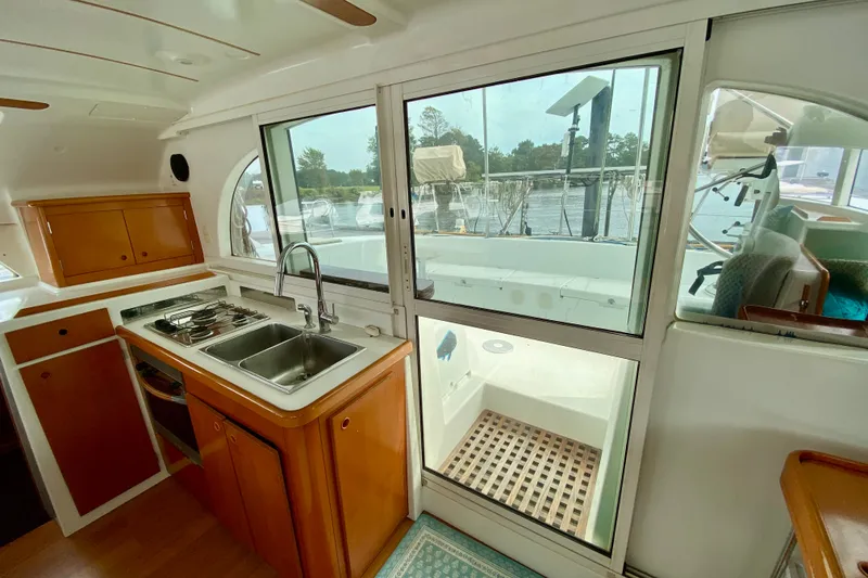 Slide: The Image of Interior view of a 2005 Lagoon 380 S2 catamaran kitchen with sink and stove. - 63