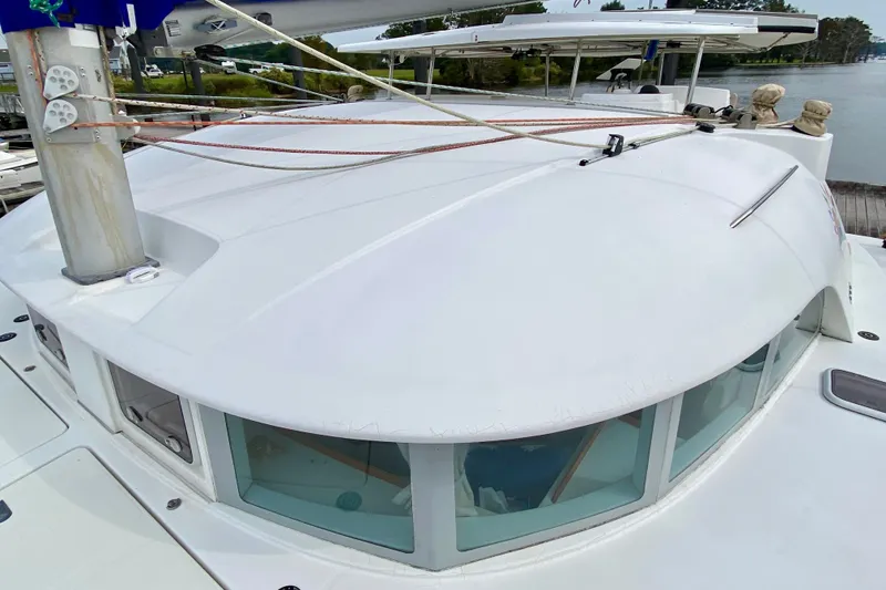 Slide: The Image of 2005 Lagoon 380 S2 catamaran deck with mast and rigging, docked by the water. - 27