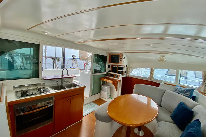 Slide: The Image of Interior of 2005 Lagoon 380 S2 catamaran with kitchen, dining area, and navigation controls. - 49