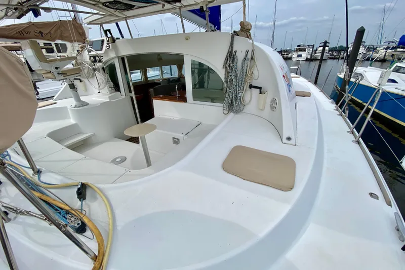 Slide: The Image of 2005 Lagoon 380 S2 catamaran docked at marina, showcasing spacious deck and helm area. - 37