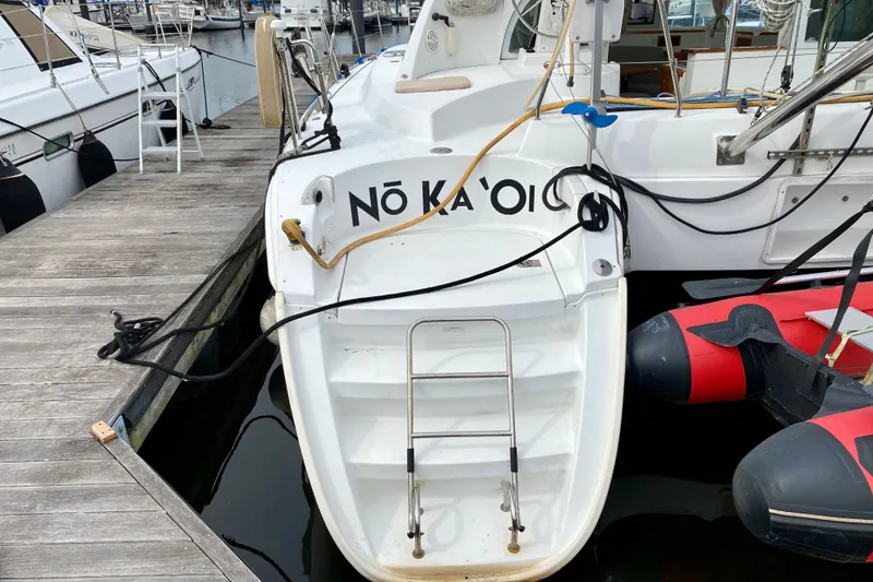 Slide: The Image of Catamaran Lagoon 380 S2, 2005 model, docked with visible ladder and inflatable boat. - 10