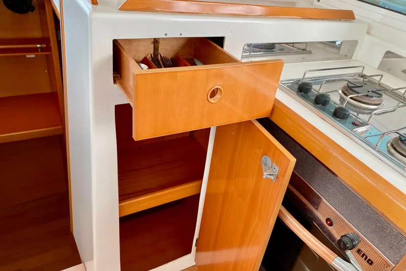 Slide: The Image of Interior of 2005 Lagoon 380 S2 yacht kitchen with open drawer and stove. - 126