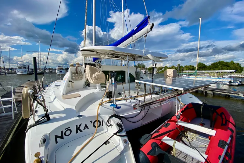 Slide: The Image of 2005 Lagoon 380 S2 catamaran docked with solar panels and inflatable boat. - 4