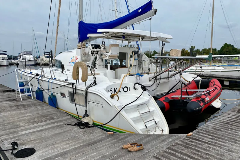 Slide: The Image of 2005 Lagoon 380 S2 catamaran docked with inflatable boat and marina background. - 2