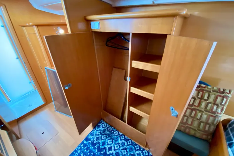 Slide: The Image of Interior of 2005 Lagoon 380 S2 yacht showing wooden wardrobe and shelves. - 109