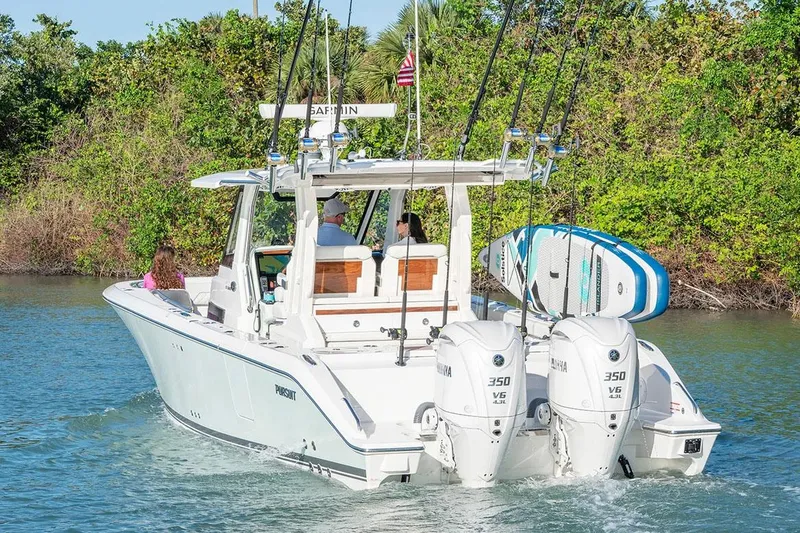 Slide: The Image of Manufacturer Provided Image: 2025 Pursuit S 328 Sport boat cruising with dual engines and paddleboards. - 5