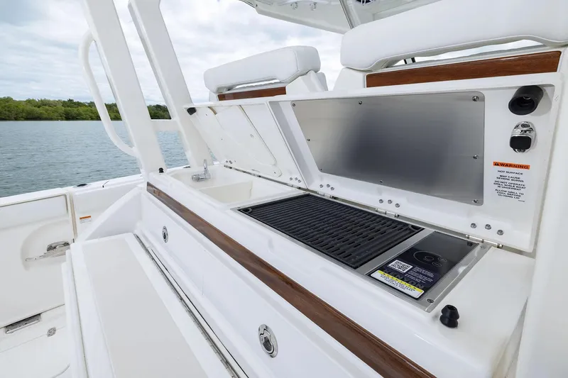 Slide: The Image of Manufacturer Provided Image: 2025 Pursuit S 328 Sport boat with onboard grill and sink, docked by water. - 14