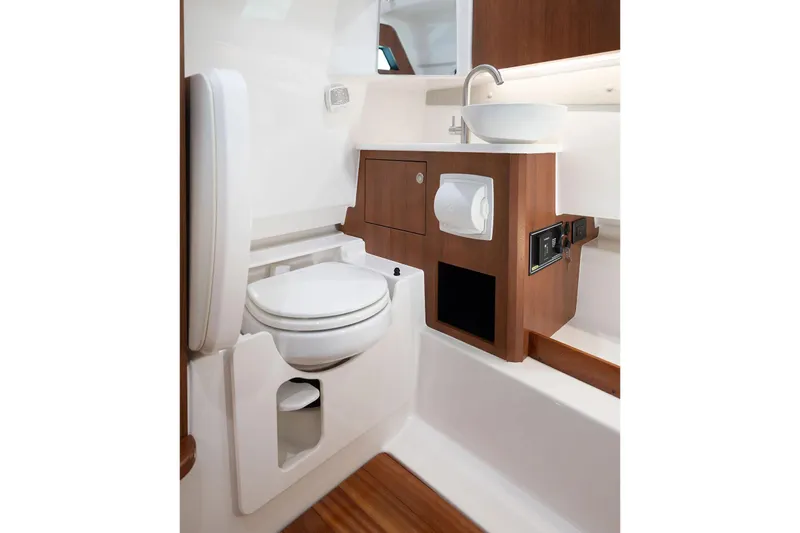 Slide: The Image of Manufacturer Provided Image: 2025 Pursuit S 328 Sport boat bathroom with toilet, sink, and wooden cabinetry. - 18