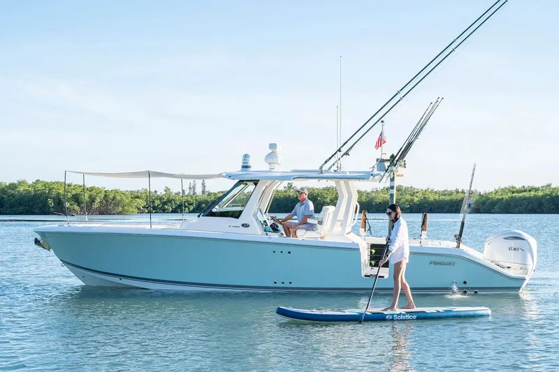 Slide: The Image of Manufacturer Provided Image: 2025 Pursuit S 328 Sport boat with paddleboarder on calm water. - 1