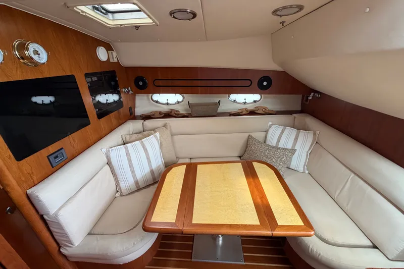 Slide: The Image of Interior of 2001 Tiara Yachts 3800 Open with cozy seating and elegant wood table. - 7