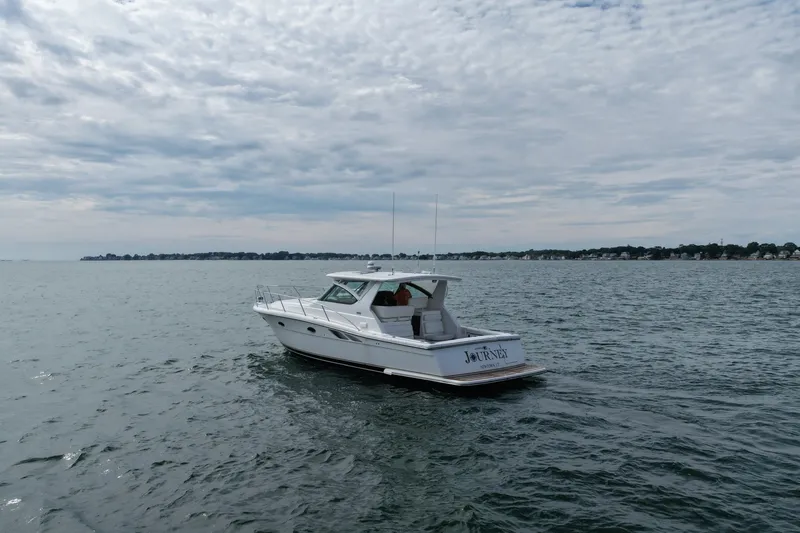 Slide: The Image of 2001 Tiara Yachts 3800 Open cruising on a calm sea under a cloudy sky. - 2