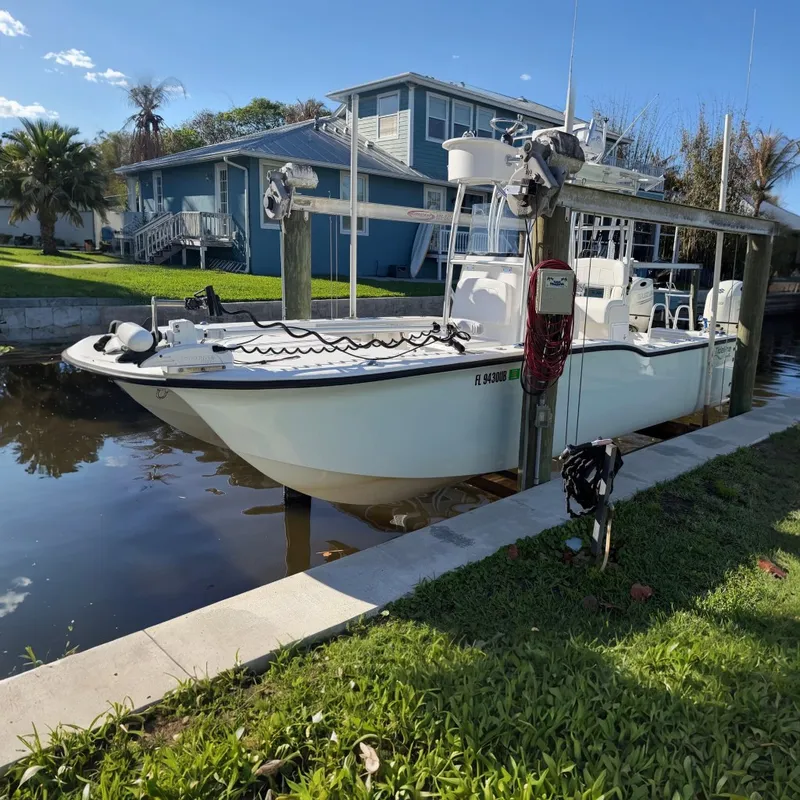 The Image of 2020 Tideline 235 Hybrid boat docked near waterfront homes, sunny day. - 0