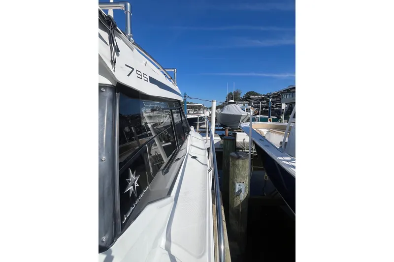 Slide: The Image of 2020 Jeanneau NC 795 boat docked at a marina under clear blue skies. - 15