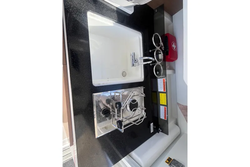 Slide: The Image of Compact kitchen area in a 2020 Jeanneau NC 795 boat with sink and stove. - 21