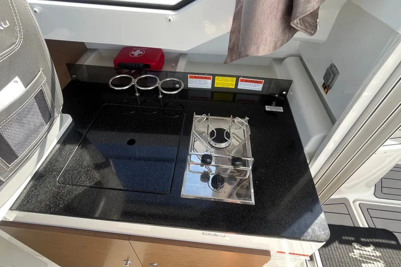 Slide: The Image of Compact kitchen area on a 2020 Jeanneau NC 795 boat with stove and safety equipment. - 20