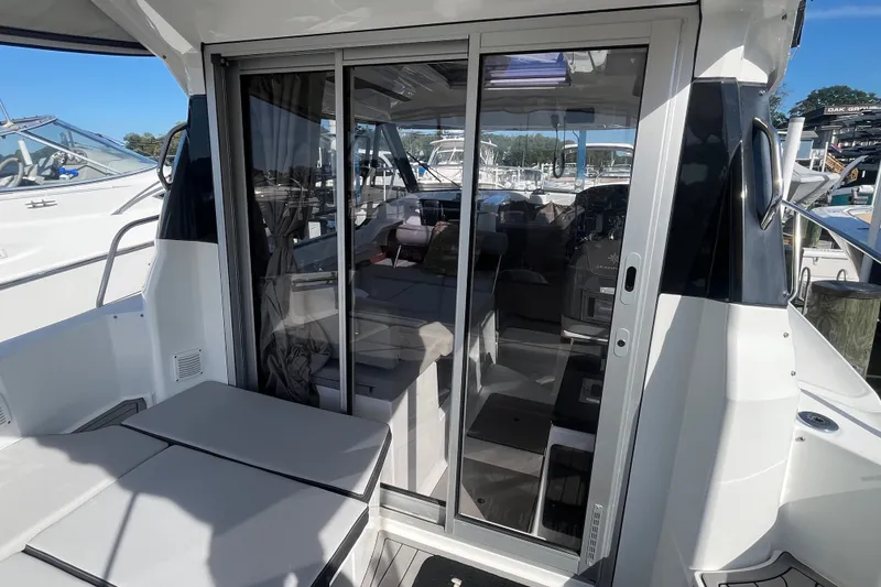 Slide: The Image of 2020 Jeanneau NC 795 boat with sliding glass doors and outdoor seating area. - 14