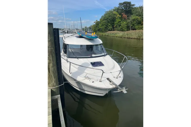 Slide: The Image of 2020 Jeanneau NC 795 boat docked in a serene marina setting. - 1