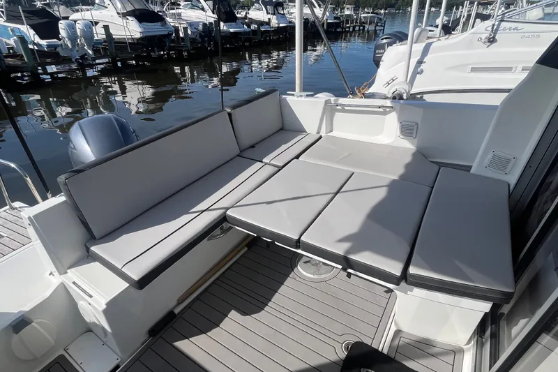 Slide: The Image of 2020 Jeanneau NC 795 boat interior with cushioned seating, docked at marina. - 13