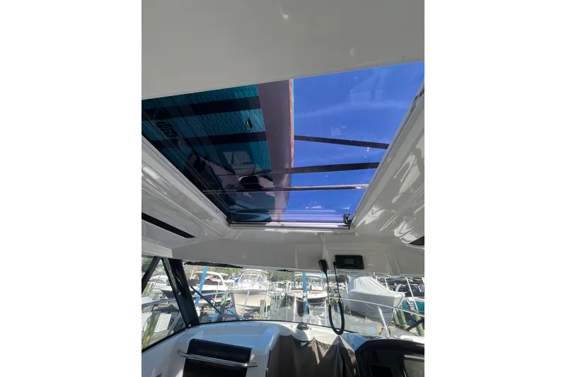 Slide: The Image of Interior view of 2020 Jeanneau NC 795 boat with open sunroof at marina. - 23