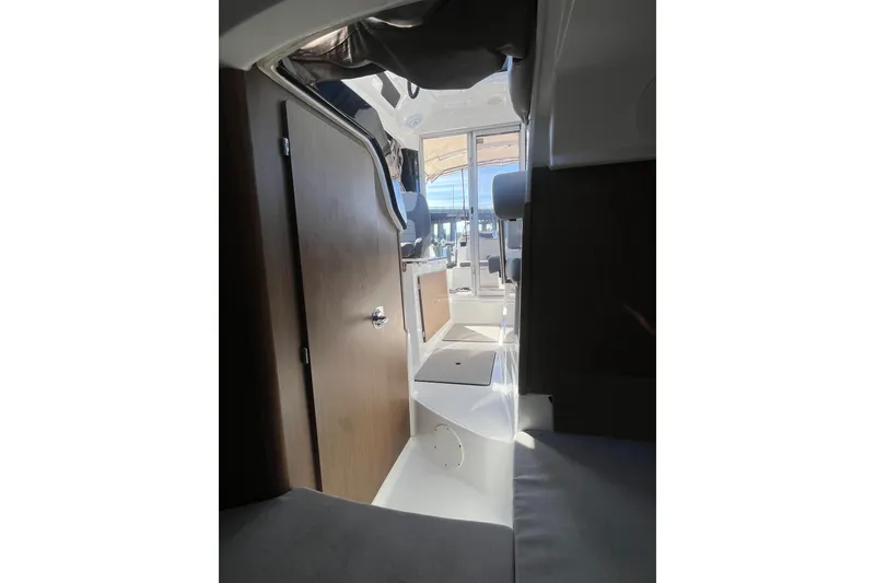 Slide: The Image of Interior view of 2020 Jeanneau NC 795 boat, featuring seating and wooden cabinetry. - 31