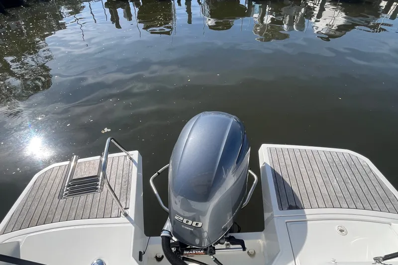 Slide: The Image of Jeanneau NC 795 boat, 2020 model, with outboard motor and swim platform on calm water. - 8