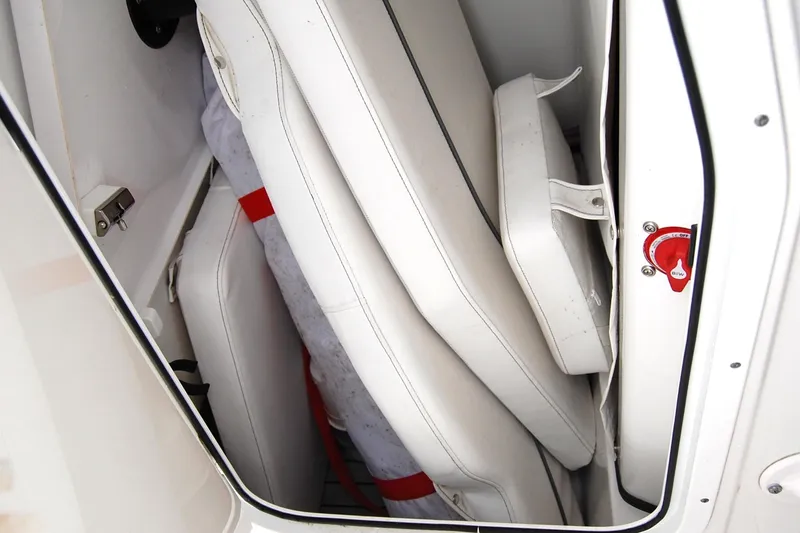 Slide: The Image of 2023 Sportsman Open 242 Center Console storage compartment with cushions and safety equipment. - 15