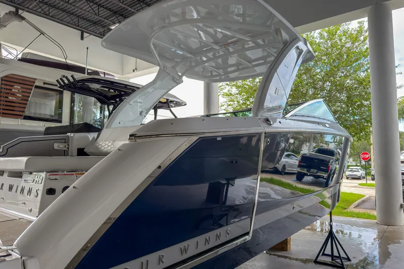 Slide: The Image of 2026 Four Winns H9 OB boat displayed indoors, showcasing sleek design and modern features. - 27