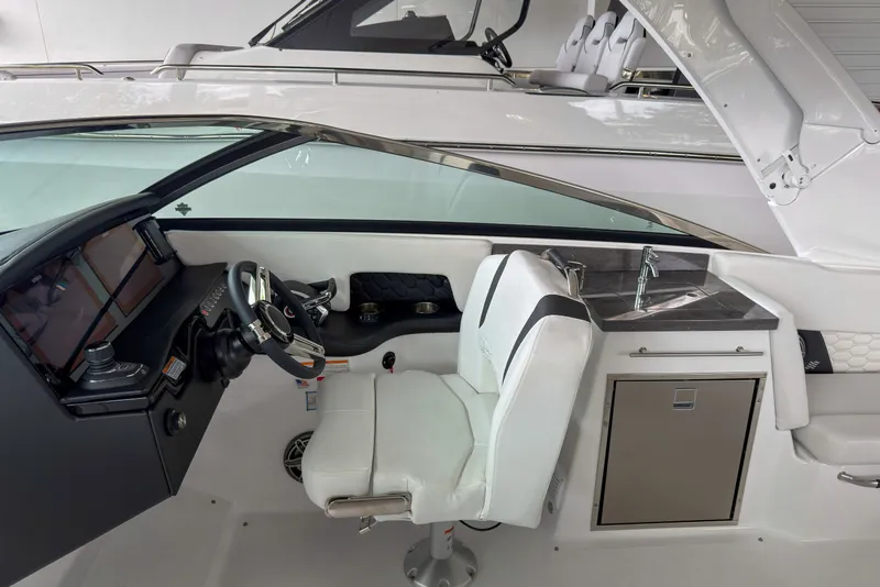 Slide: The Image of 2026 Four Winns H9 OB boat interior with steering wheel, dashboard, and sink area. - 10