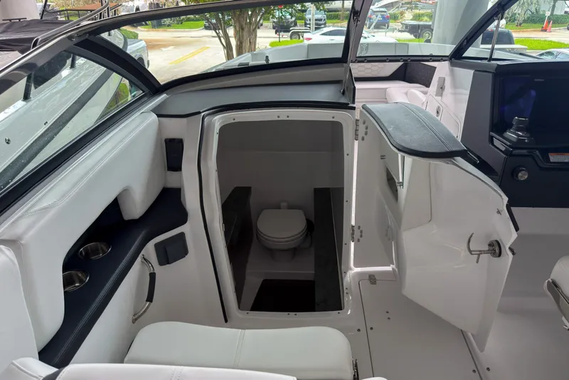 Slide: The Image of Interior of 2026 Four Winns H9 OB boat featuring a compact restroom. - 14