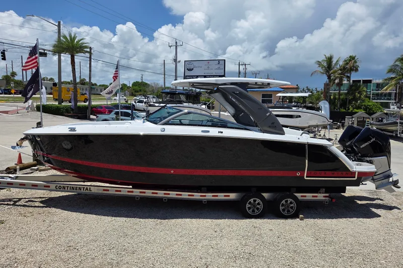 The Image of 2025 Four Winns H9 OB boat on trailer, displayed outdoors under a cloudy sky. - 0