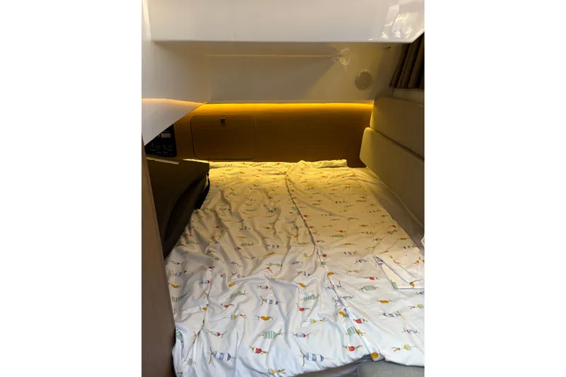 Slide: The Image of 2020 Jeanneau NC 895 cabin interior with cozy bedding and ambient lighting. - 20