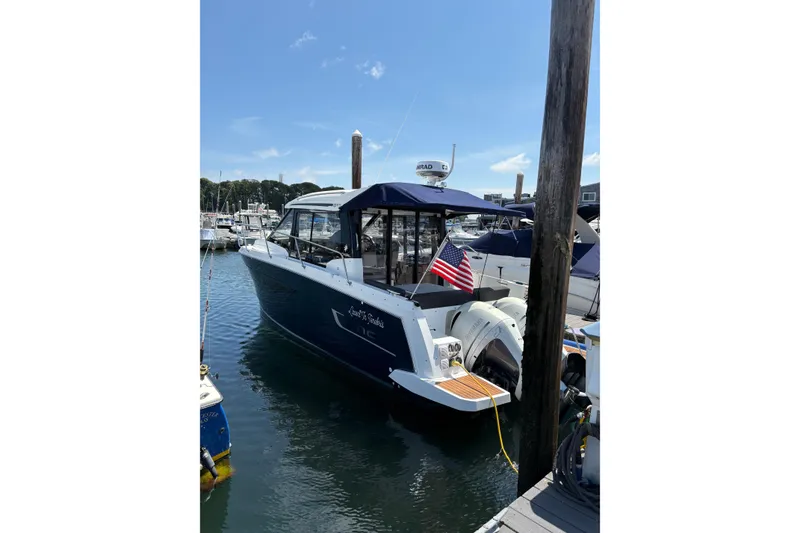 The Image of 2020 Jeanneau NC 895 boat docked with American flag, sunny day. - 3