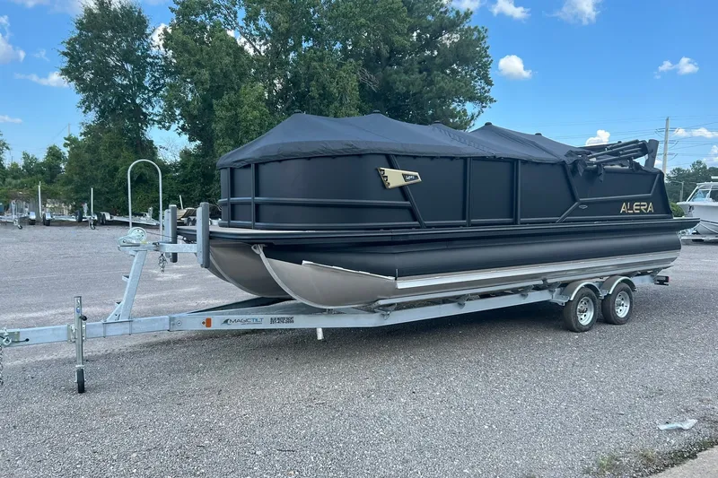 Slide: The Image of 2026 Alera M 23Q pontoon boat on trailer, covered and parked outdoors. - 3