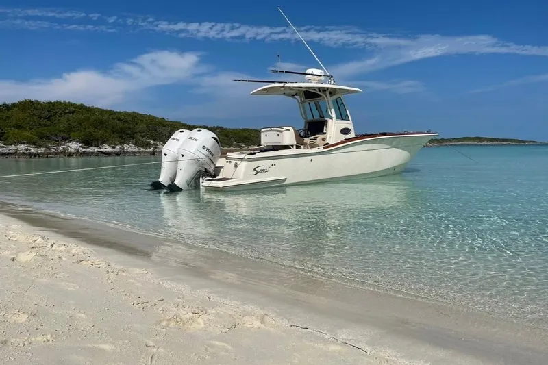Slide: The Image of 2013 Scout 275 LXF boat anchored on a clear, tropical beach. - 2