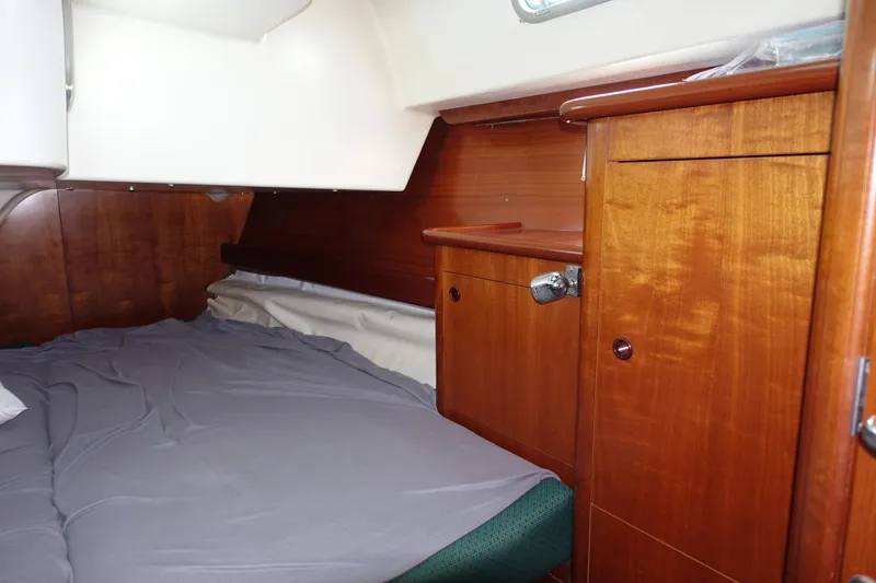 Slide: The Image of Interior cabin of 2001 Beneteau Oceanis 461 yacht with wooden cabinetry and cozy bedding. - 38