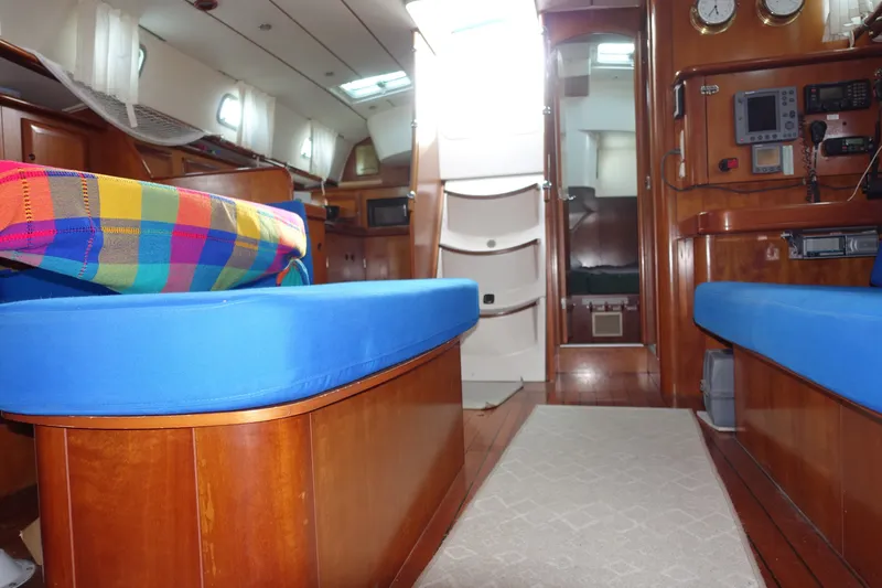 Slide: The Image of Interior of 2001 Beneteau Oceanis 461 yacht with blue seating and colorful cushions. - 35