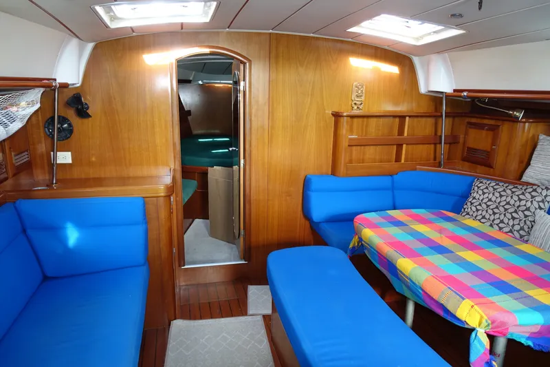 Slide: The Image of Interior of 2001 Beneteau Oceanis 461 yacht with blue seating and colorful tablecloth. - 47