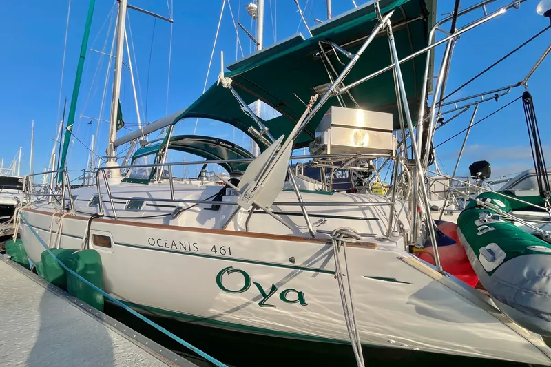 Slide: The Image of 2001 Beneteau Oceanis 461 sailboat docked, featuring green accents and clear blue sky. - 57