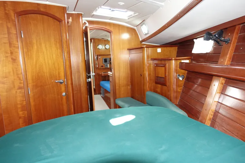 Slide: The Image of Interior of 2001 Beneteau Oceanis 461 yacht with wooden finish and green upholstery. - 27