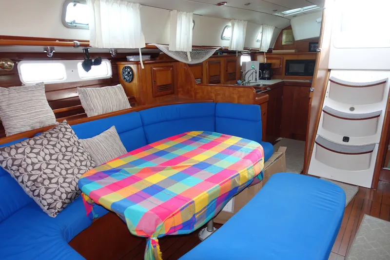 Slide: The Image of Interior of 2001 Beneteau Oceanis 461 yacht with colorful tablecloth and blue seating. - 32