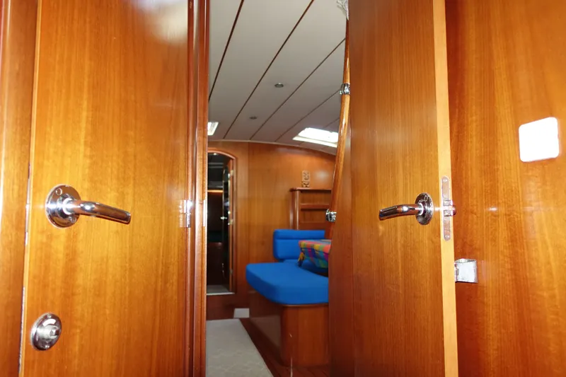 Slide: The Image of Interior view of 2001 Beneteau Oceanis 461 yacht with wooden doors and blue seating. - 52