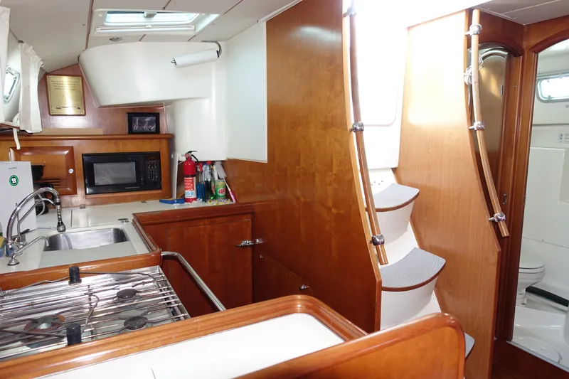 Slide: The Image of Interior of 2001 Beneteau Oceanis 461 yacht, featuring kitchen and wooden cabinetry. - 45