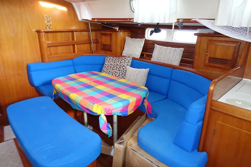 Slide: The Image of Interior of 2001 Beneteau Oceanis 461 yacht with blue seating and colorful tablecloth. - 46