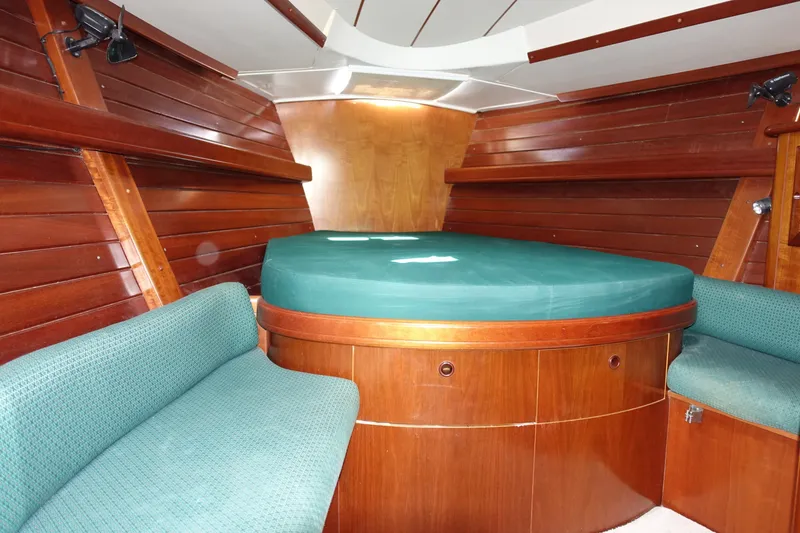 Slide: The Image of Interior cabin of 2001 Beneteau Oceanis 461 with wooden paneling and green upholstery. - 30